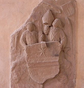 Relief mit zwei Figuren und Wappen bei der Übergabe der Bischofsmütze, Kloster Alpirsbach